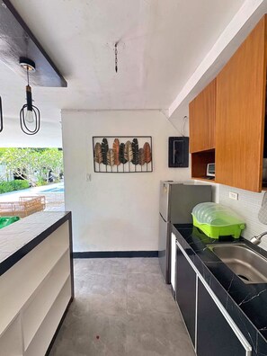A modern kitchen with a refrigerator, a sink, and a green dish rack. - Green Villa Private Resort Tropical Luxury, Private Pool & Nature Escape (Cavite)