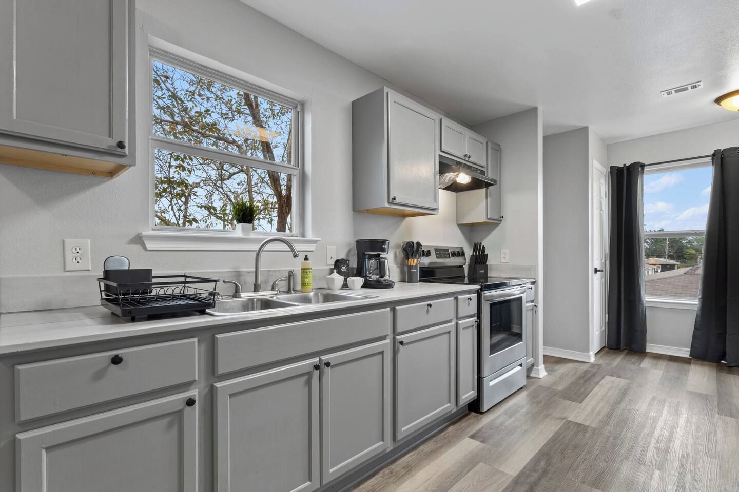 A modern kitchen with a large window, built-in appliances, and a view of the outdoors.