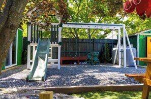 A playground with a slide, swings, and a bench. - PC+Downtown 13 Beds 3 full Baths (Providence)