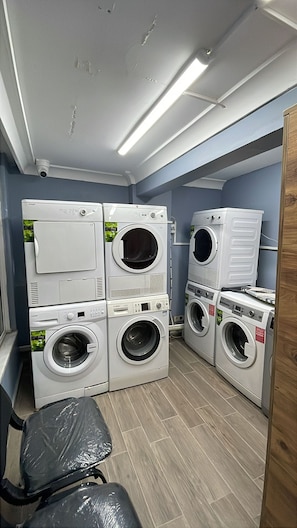 A laundry room with stacked washing machines and a chair. - KADIKÖY MERKEZDE (İstanbul)