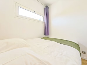 A bedroom with a bed, a window, and a curtain. - New Listing (Paris)