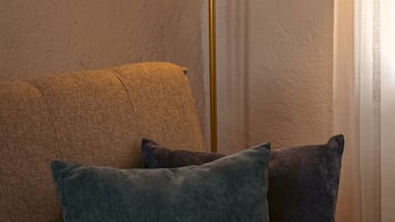 A sofa with two cushions and a floor lamp.