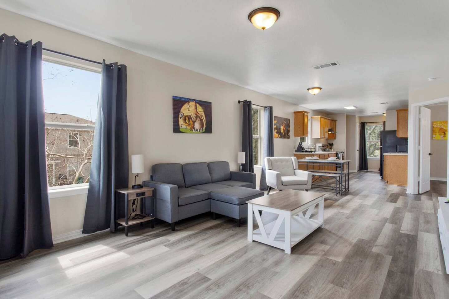 A modern living room with a sofa, a coffee table, and a dining area with a table and chairs.
