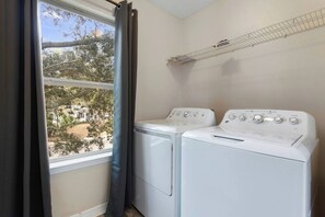 A laundry room with two front-loading washing machines and a drying rack. - Dreamworks Themed Beach Escape (Biloxi)