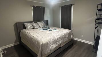 A bedroom with a bed, a ceiling fan, and a built-in shelf unit.