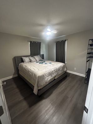 A bedroom with a bed, a ceiling fan, and a built-in shelf unit. - Adorable 3-bedroom house in Greensboro (Greensboro)
