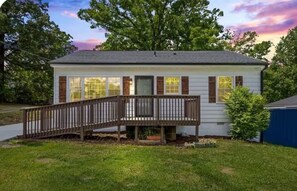 A single-story house with a front porch, a small deck, and a front yard.