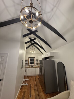 Une cuisine moderne dotée d’un îlot central, d’un luminaire suspendu et d’un réfrigérateur.