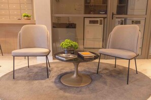 A modern room with two chairs, a round table, a small plant, and a book. - New Listing (São Paulo)