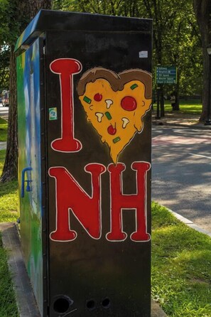 Eine Metallbox mit einer Pizzascheibe und der Aufschrift 'I NH'.