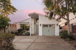A single-story house with a garage, a front porch, and a small garden area. - Oceanfront Villa with Panoramic Sunset Views! (Encinitas)