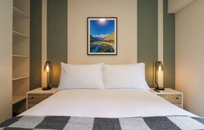 A hotel room with a bed, two bedside lamps, a framed landscape painting, and a white pillow. - w* | Fantastic 2BR with Balcony in Miraflores (Miraflores)