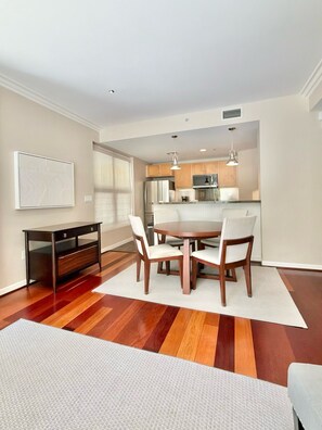 A modern kitchen with wooden cabinets, a dining table with chairs, and a small desk. - 2-BD Private Entry 2 Parking Space Corporate apartment in fabulous Downtown SD (San Diego)