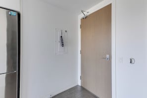 A hallway with a closed door, a light switch, and a power outlet on the wall. - Downtown Toronto Condo Suite next to Eaton Centre (Toronto)