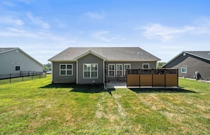 A residential house with a front yard, a wooden fence, and a clear sky. - Family Home - Near SIUE - 3BR/2BA (Glen Carbon)