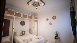 A hotel room with a bed, a mirror, a door, and a ceiling light fixture. - New Listing (Marrakech)