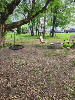 A park with a swing set, two chairs, and a fire pit. - Train Tracks Getaway - 2-bedroom house in peaceful Odenton close to MARC (Odenton)