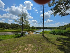 A river with a boat docked on the bank, surrounded by trees and greenery. - Bass & Jellyfish Retreat 3BR, 2BA Sleeps More with Flexible 4-Bedroom Setup (Athens)