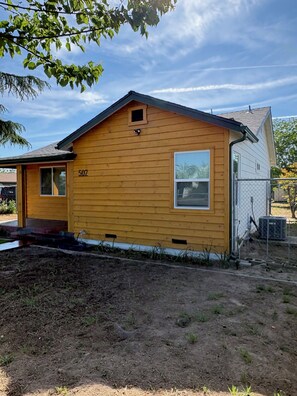 A single-story wooden house with a gabled roof, a front porch, and a visible number '507' on the side. - The Valley Haus (Sanger)