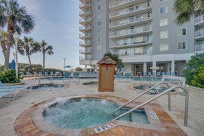A hotel pool area with multiple hot tubs and lounge chairs. - Sea Watch Oceanfront Escape | Balcony Views, King Bed, Pools & Lazy Rivers (Myrtle Beach)