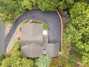 An aerial view of a property with a paved driveway, a large building with a flat roof, and surrounding greenery. - Charming 6-bedroom house in Wintergreen Resort with AC (Wintergreen Resort)