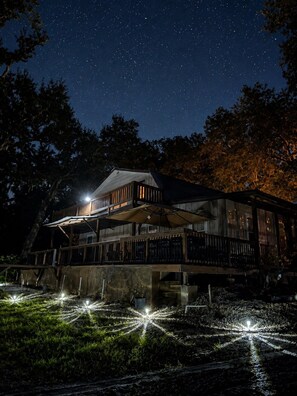 Un bâtiment en bois à deux étages, doté d’un balcon, sous un ciel étoilé.