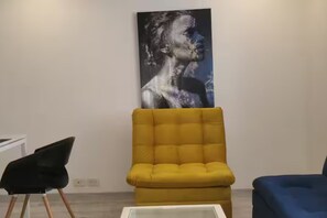 A room with a yellow armchair, a blue armchair, and a white coffee table. - New Listing (Bogotá)