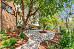 A paved outdoor area with a tree, a bench, and a table. - Sunlit South Yarra 2BR Apartment | Free Parking (South Yarra)