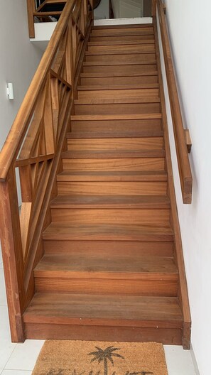 A wooden staircase with a handrail, leading to an upper floor. - New Listing (Jan Thiel)