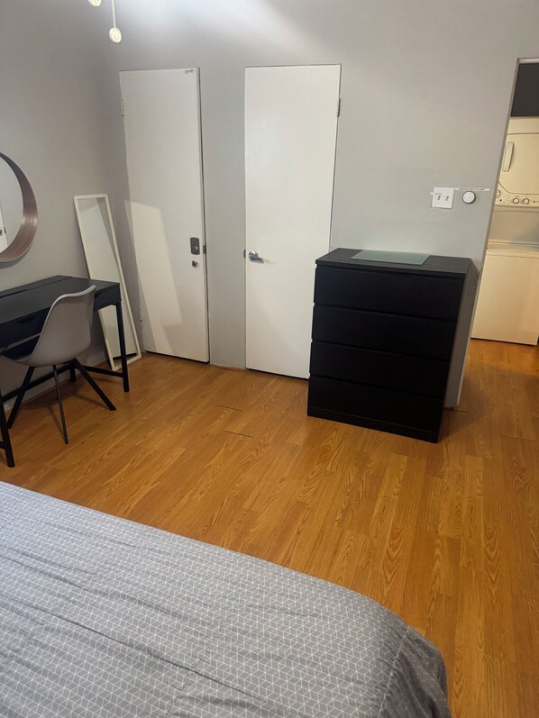A room with a bed, a desk, a chair, a dresser, and two doors. - Cozy 1-bedroom apartment in delightful Houston with AC in the Midtown Area (Houston)