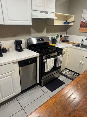 A kitchen with a stove, dishwasher, and a coffee maker. - Cozy 1-bedroom apartment in delightful Houston with AC in the Midtown Area (Houston)