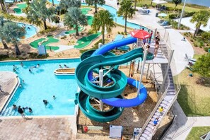 A water park with a large pool, a multi-level water slide, and a golf course. - Lake View 2BR Condo Near Disney (Kissimmee)