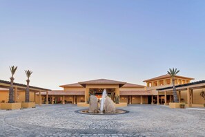 A hotel courtyard with a central fountain, palm trees, and a building with a tiled roof. - 1 bdrm Christmas week in 5 star Grand Fiesta Americana Los Cabos Golf/Spa Resort (Cabo San Lucas)