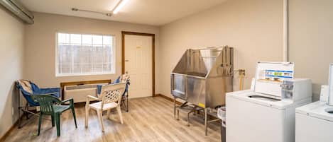 A laundry room with a washing machine, dryer, and a metal drying rack.