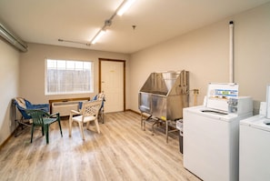 A laundry room with a washing machine, dryer, and a metal drying rack.