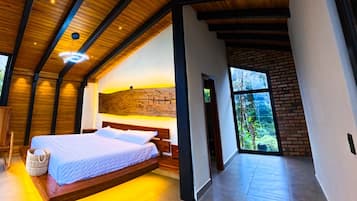 A modern bedroom with a wooden ceiling, a large bed, and a view of the outdoors.