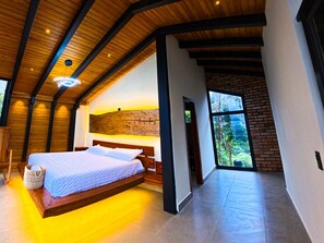 A modern bedroom with a wooden ceiling, a large bed, and a view of the outdoors. - Kilamo Sky: Sleep Under the Stars, Wake Up in Paradise - Macas Ecuador (Macas)