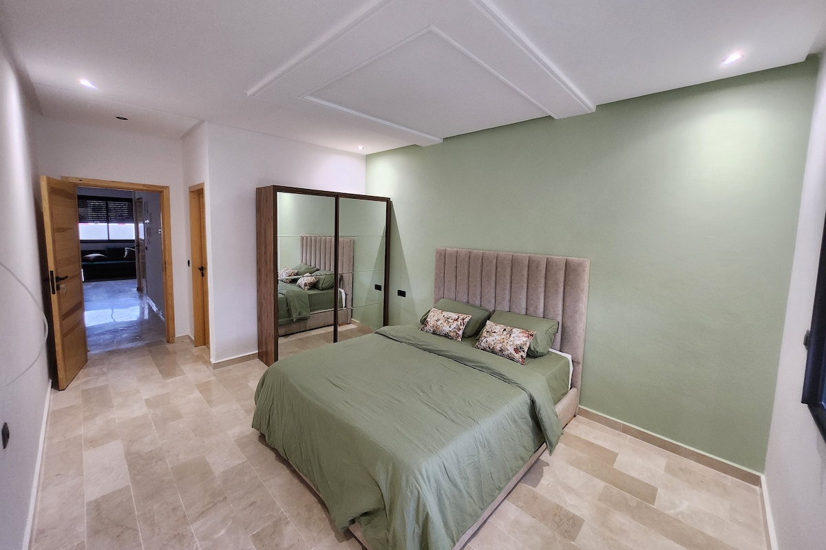 Una camera da letto con un letto, uno specchio e una porta che dà su un'altra stanza.