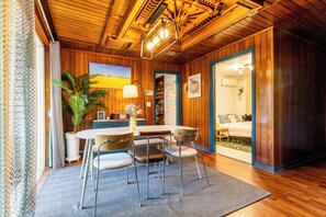 A cozy room with a wooden ceiling, a dining table with chairs, a large potted plant, and a painting on the wall. - Private 3-bedroom House w/ Scenic Mt. View & Private Garden in Historic Jongro (Seoul)