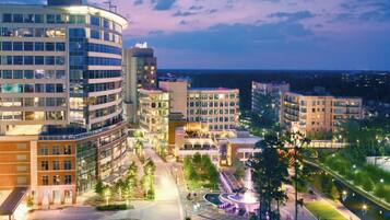 A modern urban hotel complex with multiple buildings, a central courtyard, and a waterfront view.