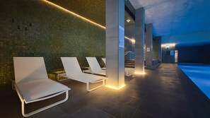 A modern indoor relaxation area with lounge chairs and a tiled floor. - Stylish Apt | King Bed, Balcony, Free Car Park & Indoor Swimming Pool (Docklands)