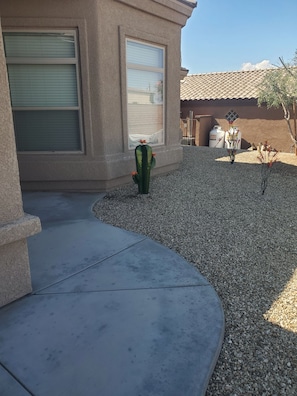 A residential area with a house, a cactus, and a gravel driveway. - Caravan House RV garage for short term or winter visits (Lake Havasu City)