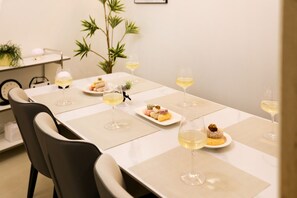 Une table à manger avec des sets de table, des assiettes remplies de nourriture et des verres à vin.