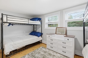 A bunk bed with white bedding, a dresser with drawers, and a window with blinds. - Wood Pond Lodge - Single Fam Oasis on 3 acres (Middlesex)