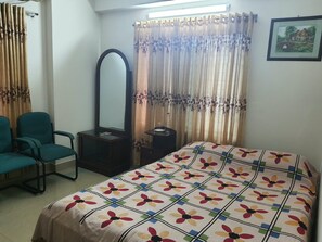 A bedroom with a bed, a chair, a dresser, a mirror, and curtains. - Marvelous 2-bedroom apartment with AC in vibrant Dhaka (Dhaka)