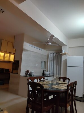 A compact kitchen with a dining area, a ceiling fan, and a refrigerator. - Marvelous 2-bedroom apartment with AC in vibrant Dhaka (Dhaka)
