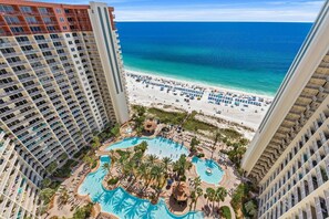 Ein Hochhaus-Hotel mit Poolbereich, Strand und Meerblick.