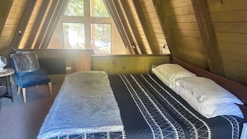 A room with a bed, a chair, and a window.
