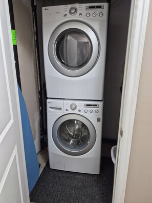 A stacked washer and dryer unit in a laundry room. - D-king's Royal Court (Regina)