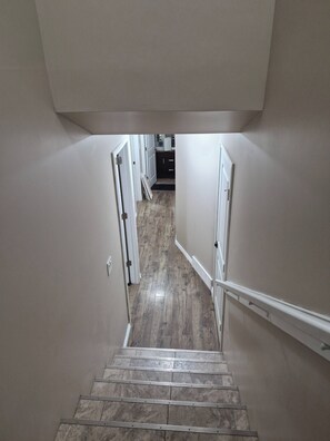 A staircase leading to a landing with a kitchen area in the background. - D-king's Royal Court (Regina)